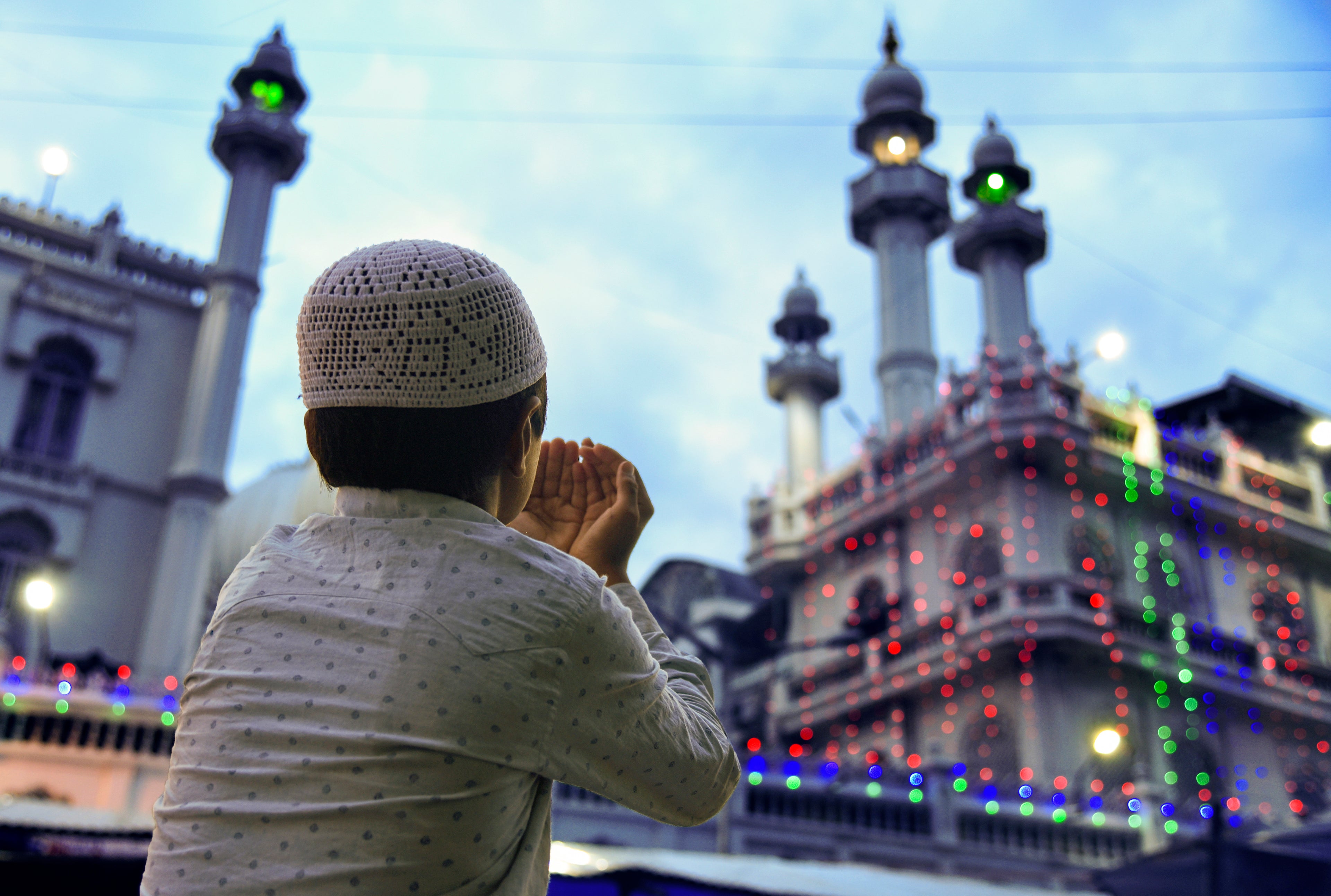 Young Muslim boy raising his hands in duaa, praying to Allah